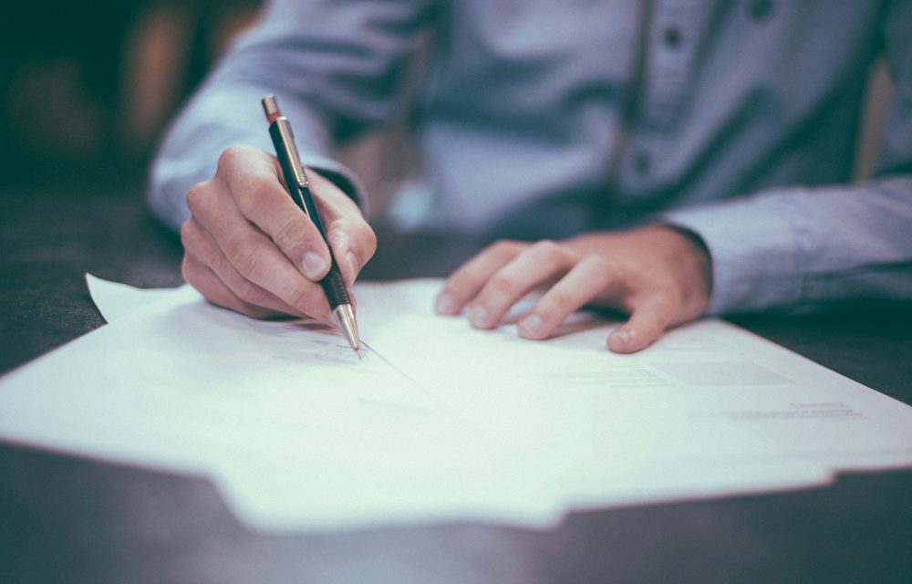 Signing a business document at a desk